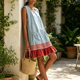 Vestido tipo túnica azul-claro, sem mangas, com uma risca vermelha e folhos na bainha